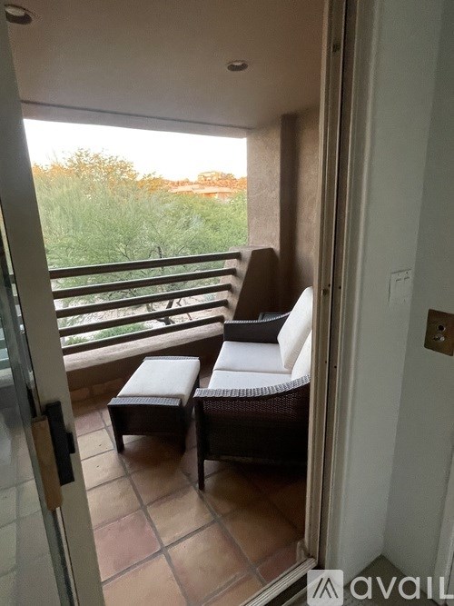 A balcony with two chairs and a table.