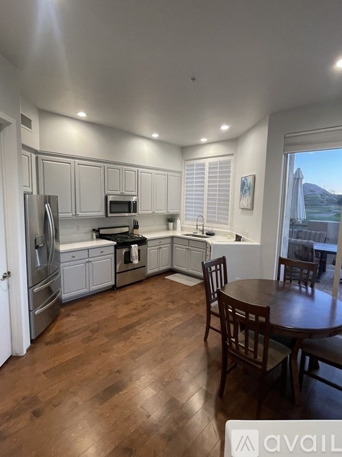 A kitchen with a table and chairs in front of a window.