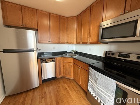 A kitchen with wooden cabinets and a stainless steel refrigerator.