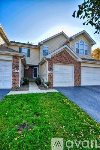 A two-story house with a garage and a driveway.