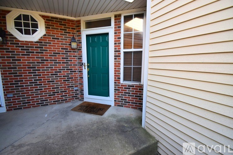 A house with a green door and a window with blinds.