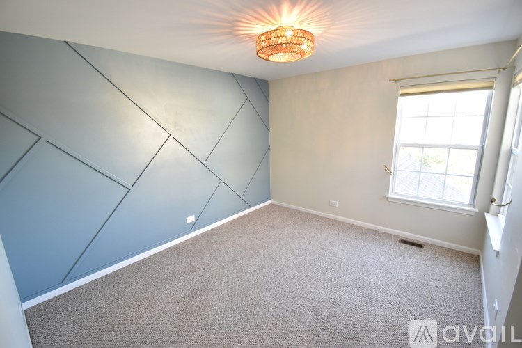 A room with a window and a carpeted floor.