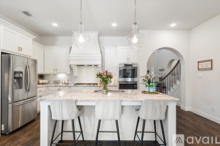 A kitchen with a center island and a refrigerator on the left.