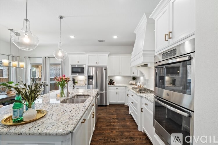 A modern kitchen with white cabinets and stainless steel appliances.