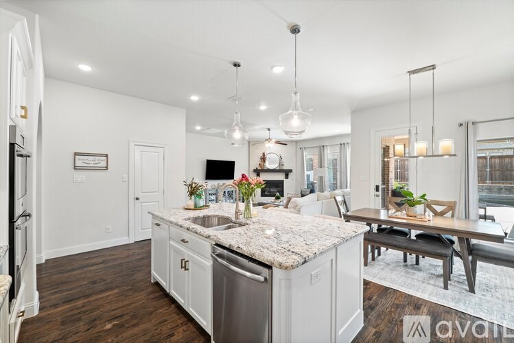 A kitchen with a marble countertop and a dining area with a table and chairs.