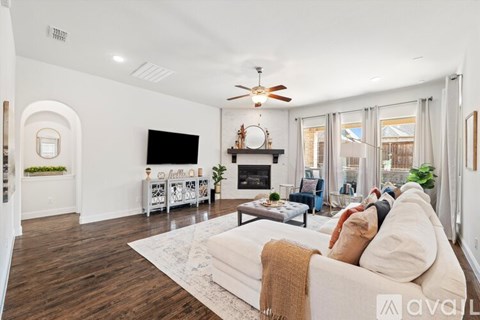 A living room with a white couch and a fireplace.