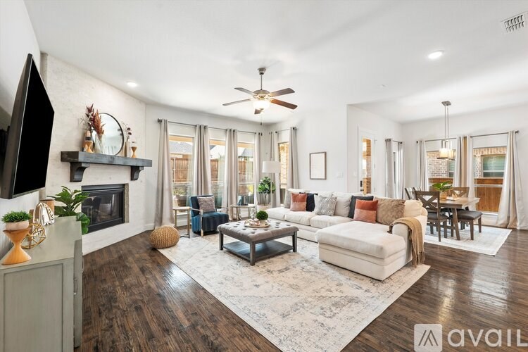 A living room with a fireplace and a television on the wall.
