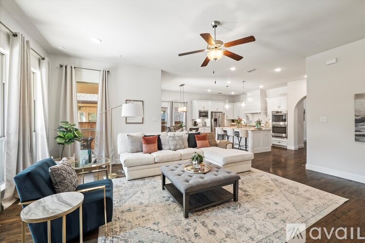 A living room with a blue chair and a grey sofa with a rug on the floor.