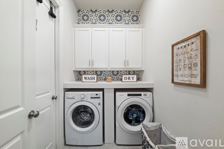A laundry room with two wash and dry machines.