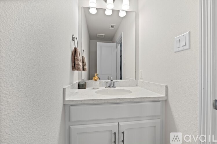 A bathroom with a white sink and a mirror.