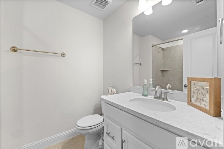 A bathroom with a white toilet and a marble countertop.