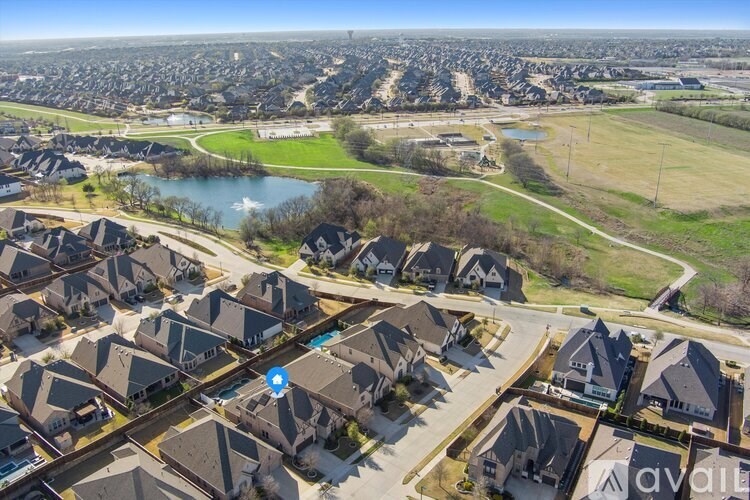 A bird's eye view of a residential area with houses and a lake.
