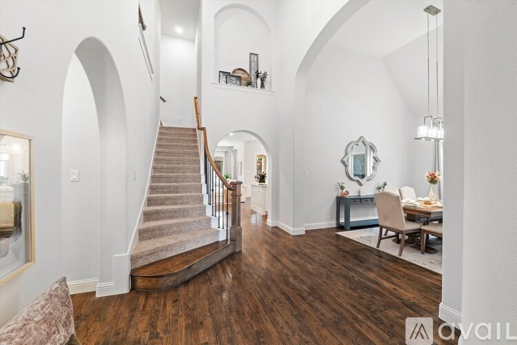 A spacious living room with a staircase and a dining area.