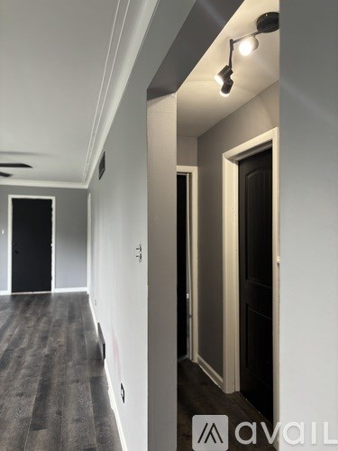 A hallway with a light on the ceiling and a door on the right.