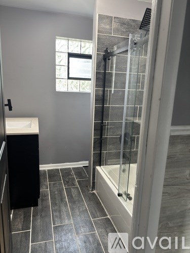 A bathroom with a walk-in shower and a window.