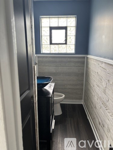 A bathroom with a toilet and a window.