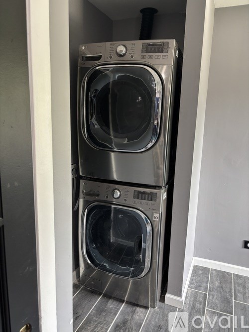 A stacked washer and dryer in a small room.