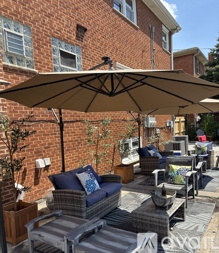 A patio with a couch, table, and umbrella.