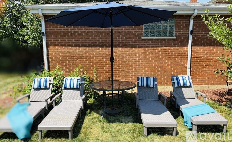 A patio with a table, chairs, and an umbrella.