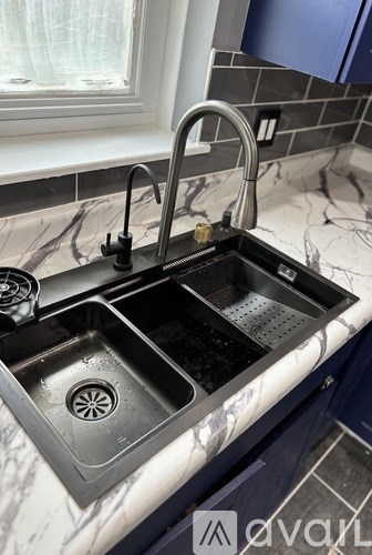 A kitchen sink with a faucet and a window above it.