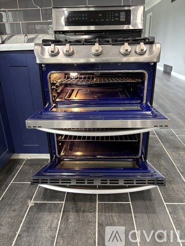 A modern kitchen with a blue oven and a digital stove top.