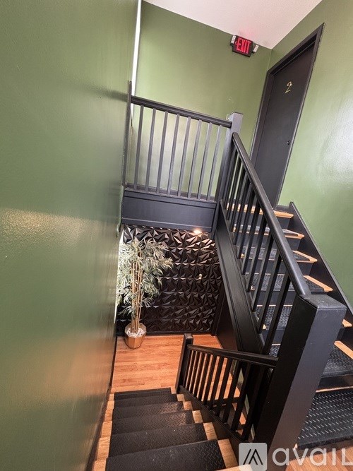 A staircase with a black railing and wooden steps.