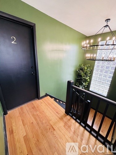 A black door with the number 2 on it is in a room with wooden floors.