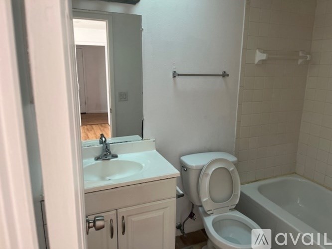 A white bathroom with a toilet and a bathtub.