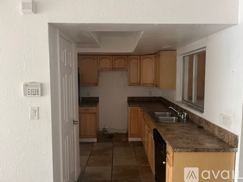 A kitchen with wooden cabinets and a granite countertop.