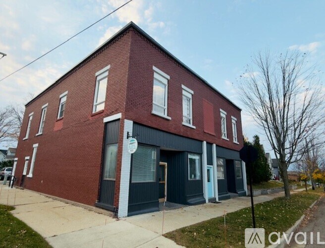 A red brick building with a blue trim around the windows and doors.