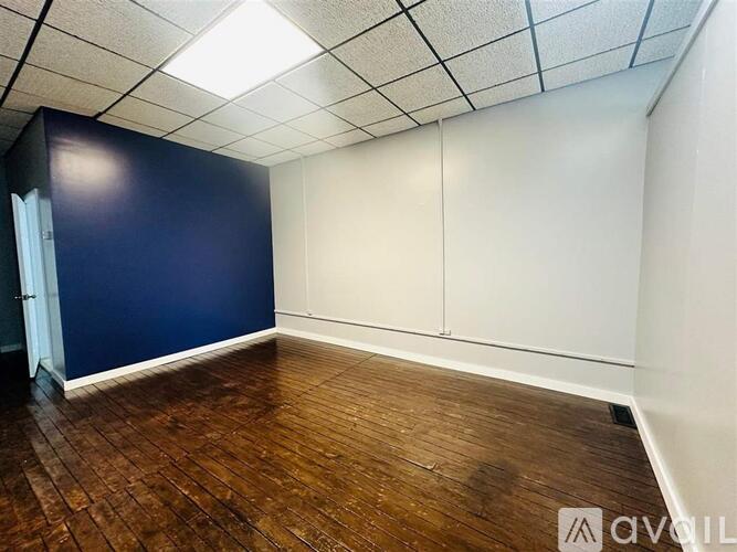 Empty room with wooden floor and white walls.
