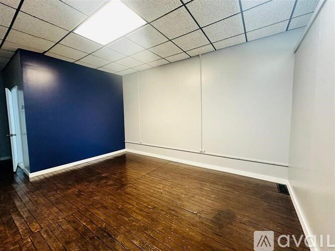 Empty room with wooden floor and white walls.