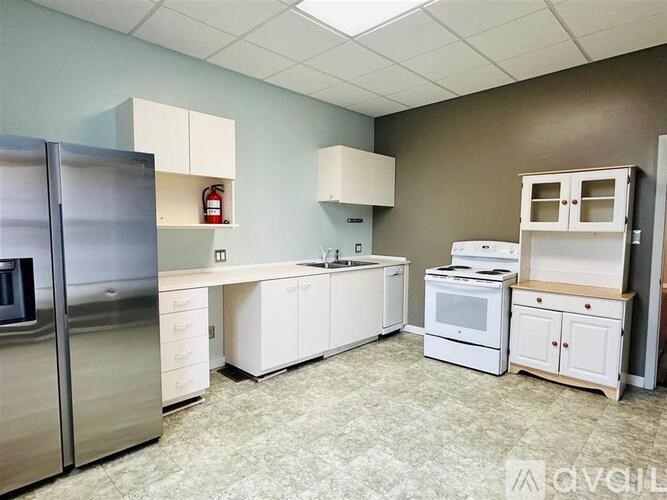 A kitchen with white appliances and cabinets.