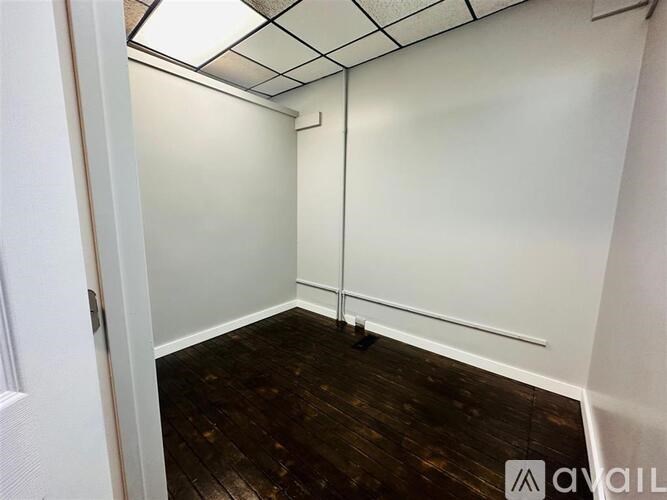 A room with white walls and a wooden floor.