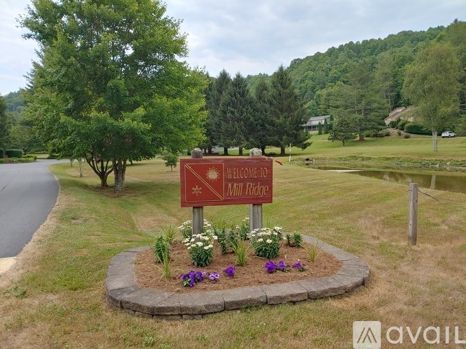 A sign that says "Welcome to Hill Ridge" is surrounded by flowers and greenery.