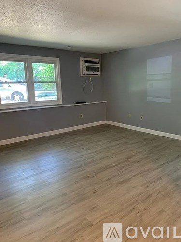 A room with a window and a wall-mounted air conditioner unit.
