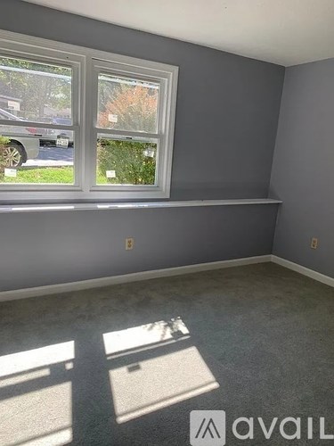 A room with a window and a wall shelf.