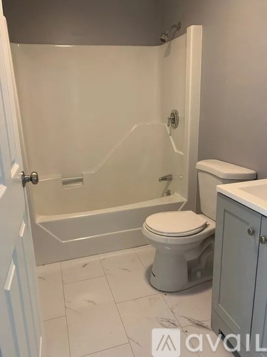 A white toilet sits in a bathroom next to a walk-in shower.