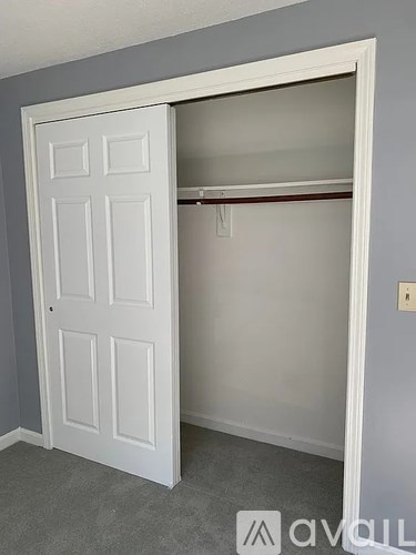 A white door is open to a white closet.