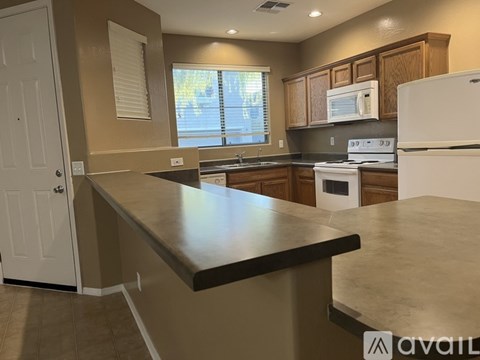 A kitchen with a white refrigerator, microwave, and stove top oven.