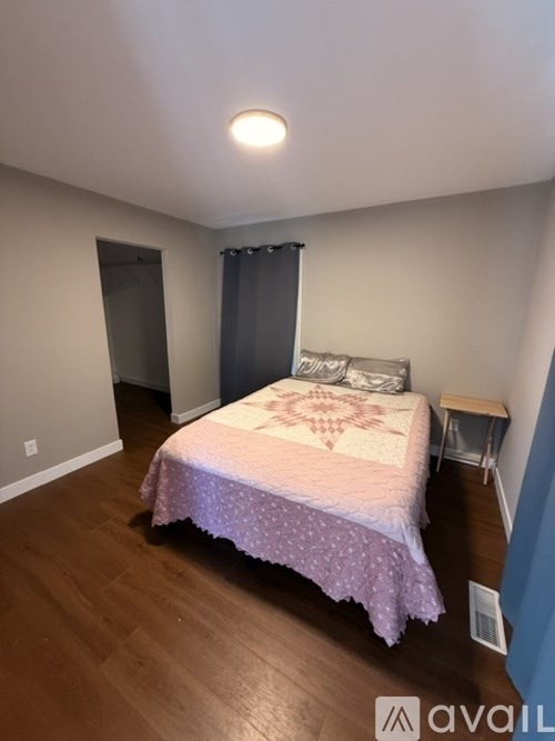 A bedroom with a bed, a small table, and a closet.