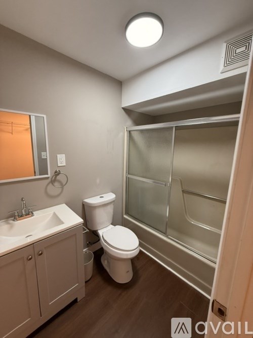 A bathroom with a toilet, sink, and shower.