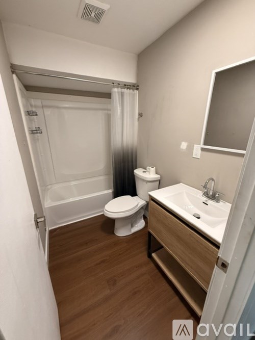 A bathroom with a toilet, sink, and shower.