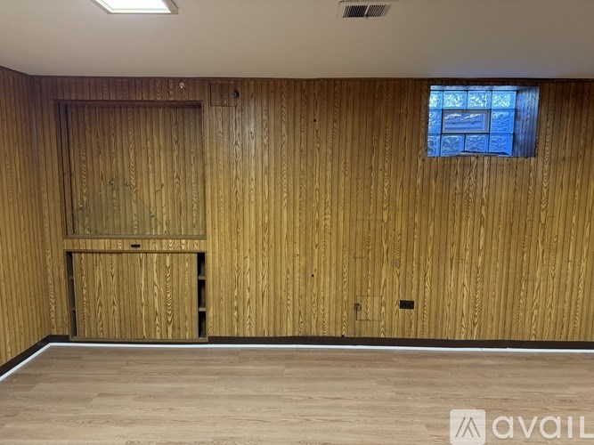 A room with wooden walls and a window.