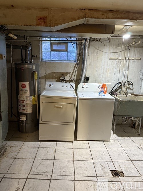 A room with a water heater and a sink.
