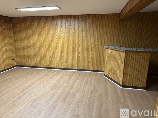 A room with wooden flooring and a wooden wall panel.