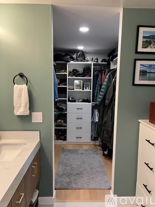 A bathroom with a white sink and a white cabinet with a white towel hanging on a towel ring.