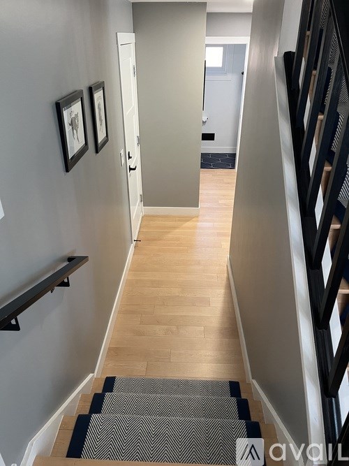A hallway with a staircase and a railing.
