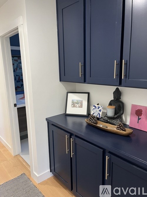 A kitchen with dark blue cabinets and a wooden tray on top of one.