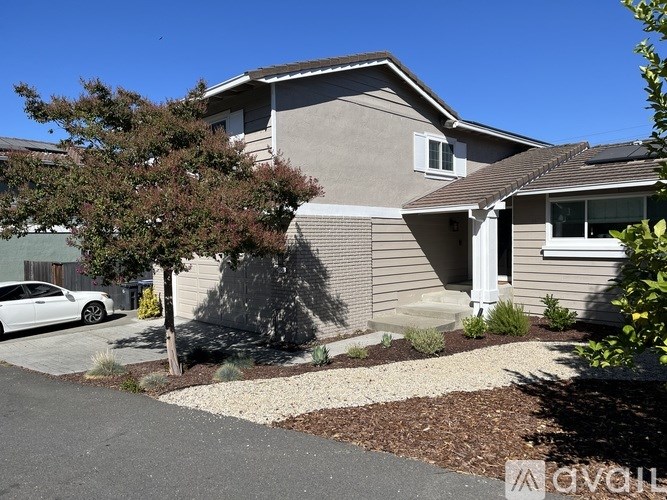 A house with a white car parked in front.